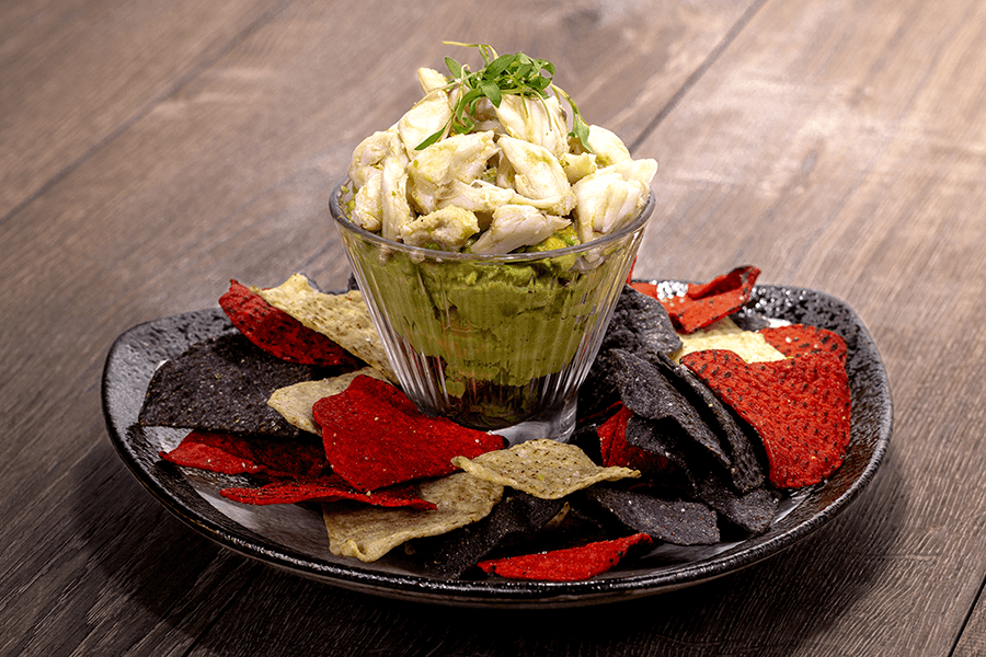 Savory crab guacamole with chunks of fresh crab meat, ripe avocado, diced tomatoes, and a hint of lime, perfect for dipping or spreading.